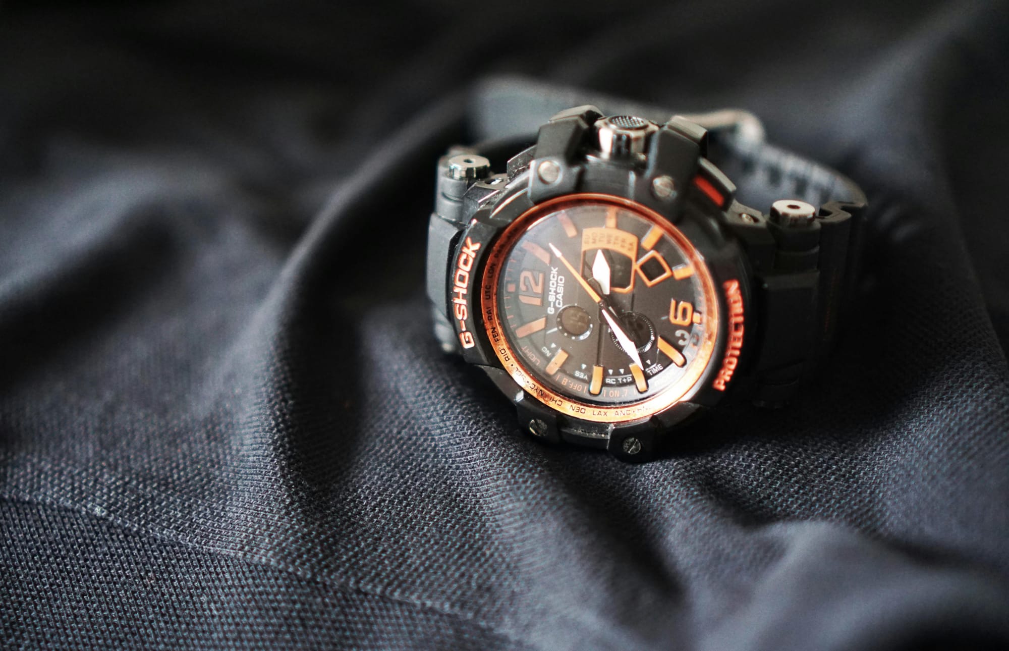 Casio G-Shock watch on dark fabric; a battery-powered quartz watch requiring regular battery replacement